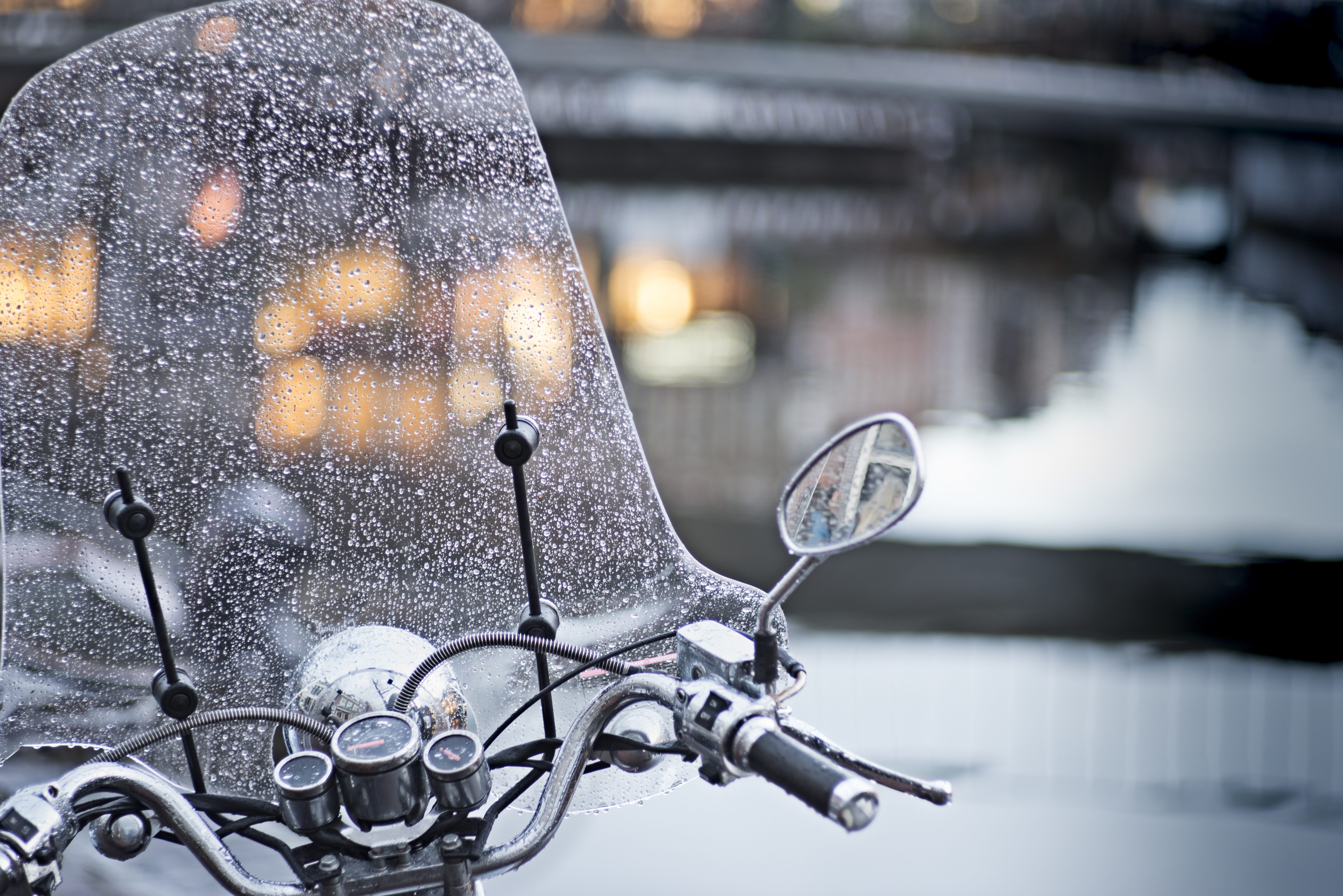 Rainy evening in Leiden and scooter parked near canal